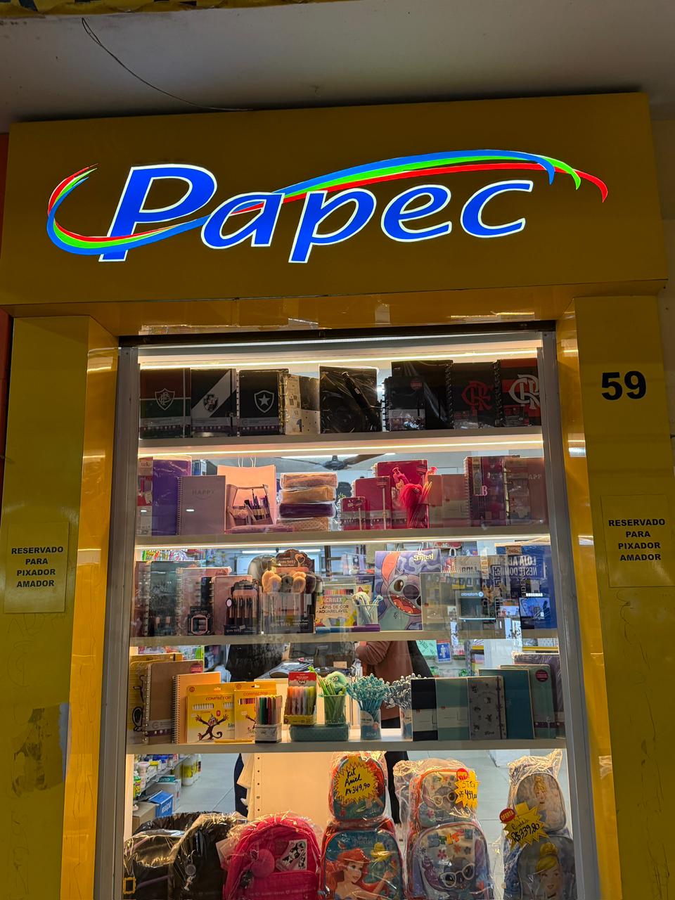 Interior da loja Papec Papelaria, com mochilas e material escolar